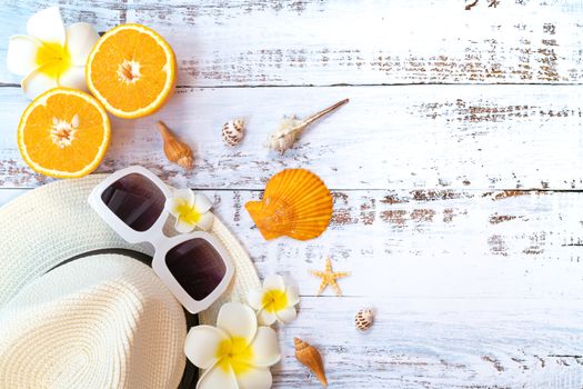 Beautiful summer holiday, Beach accessories, orange, sunglasses, hat and shells on wooden backgrounds