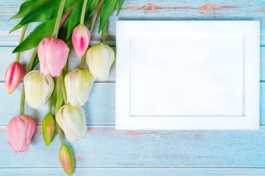 white picture frame and flower on wooden table background