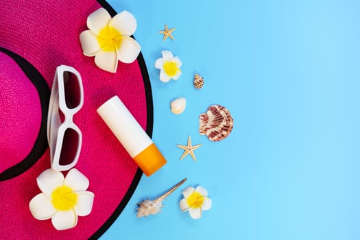 Beautiful summer holiday, Beach accessories, sunglasses, hat, sunblock and shells on blue backgrounds