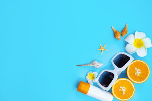 Beautiful summer holiday, Beach accessories, orange, shells and sunblock on blue backgrounds