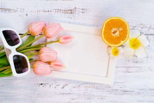 Beautiful summer holiday, Beach accessories, orange, sunglasses, flower and photo frame on wooden backgrounds