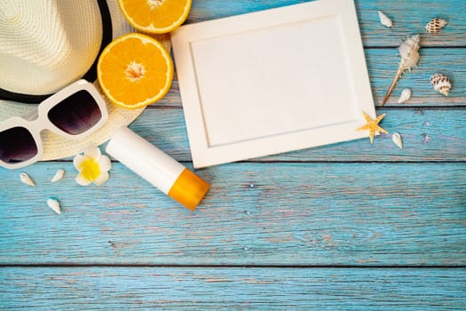 Beautiful summer holiday, Beach accessories, orange, sunglasses, hat and sunblock on wooden backgrounds