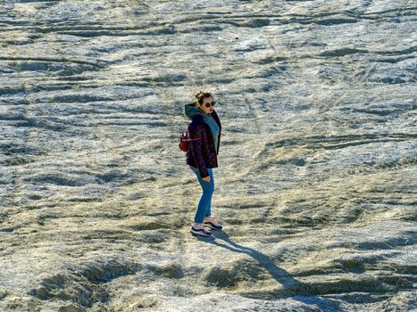 young woman with red jacket and abndoned Quarry Of Rummu, Estonia on the background. Scenic View Of Land Against Clear Blue Sky. Panoramic View.