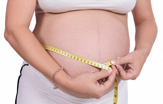 A pregnant woman measuring her belly