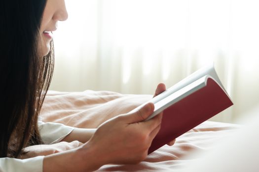 world book day, woman lay on bed reading the blank book