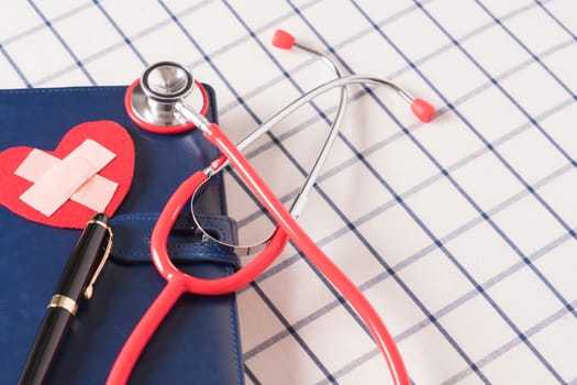 World health day healthcare and medical concept red stethoscope and red heart shape on the blue daily notebook