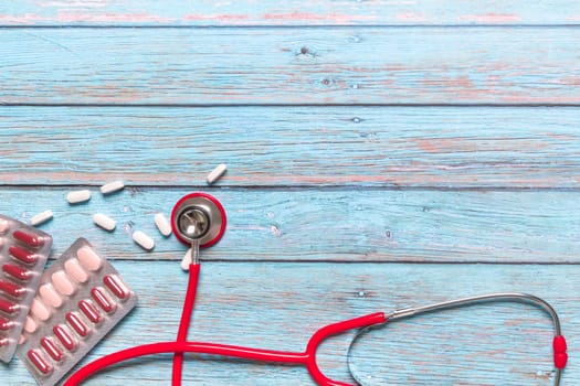 World health day healthcare and medical concept red stethoscope and medicine on the blue wooden background