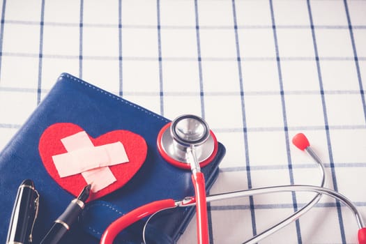 World health day healthcare and medical concept red stethoscope and red heart shape on the blue daily notebook
