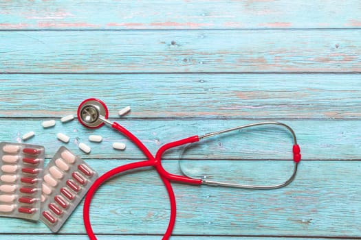 World health day healthcare and medical concept red stethoscope and medicine on the blue wooden background