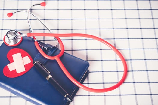 World health day healthcare and medical concept red stethoscope and red heart shape on the blue daily notebook