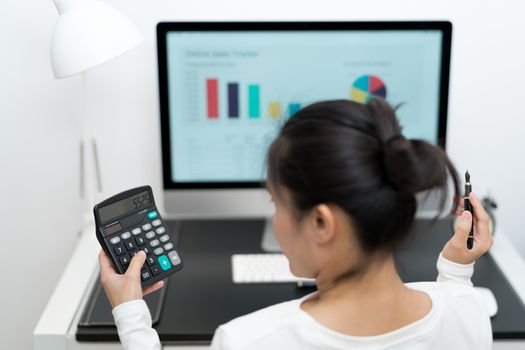 young business women work with calculator and computer desktop and pen on the modern work table