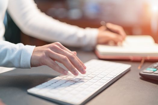 young business women typing on keyboard at office - filter applied