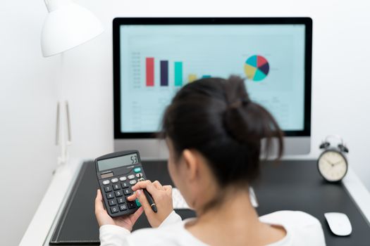 young business women work with calculator and computer desktop and pen on the modern work table