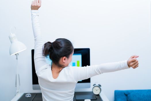 Young Asian beautiful woman sitting in front of computer and stretch oneself  after long working. stree-free and relax