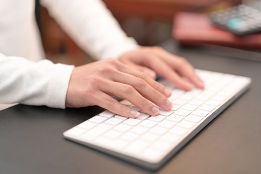 financial advisor typing on keyboard while sitting at office and working on computer