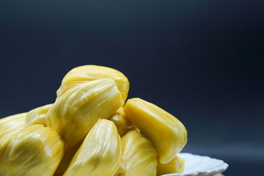 Fresh jackfruit slices on a white plate. sweet yellow jackfruit ripe. vegetarian, vegan, raw food. Exotic tropical fruit - closeup isolated