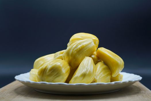 Fresh jackfruit slices on a white plate. sweet yellow jackfruit ripe. vegetarian, vegan, raw food. Exotic tropical fruit - isolated