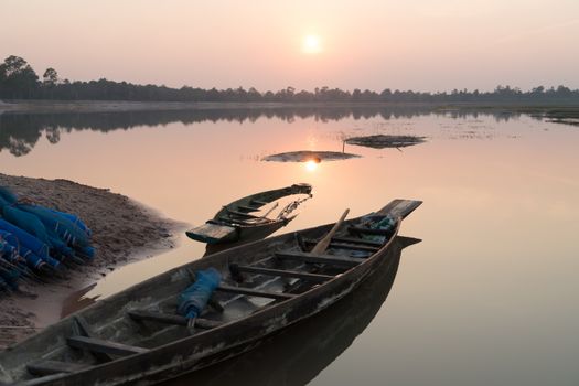 Fishing boat parking on the riverside evening clouds on sunset, Roi Et, Thailand