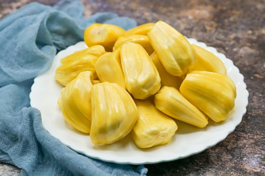Fresh jackfruit slices on a white plate. sweet yellow jackfruit ripe. vegetarian, vegan, raw food. Exotic tropical fruit - isolated