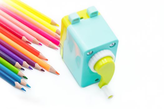 pastel blue yellow rotary pencil sharpener shavings with wooden colorful pencils isolated on white background, back to school education concept