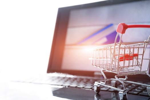 online shopping concept. Shopping cart trolley on the laptop with a credit card on the zipper bag