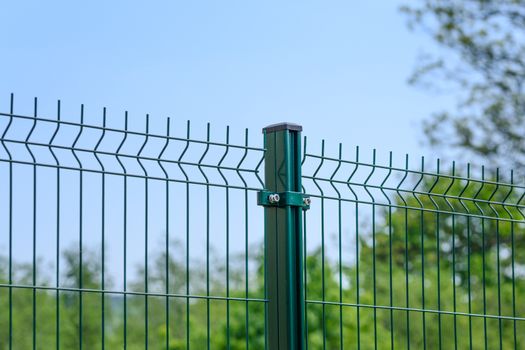 Close-up of a metal fence wire on blue sky background        