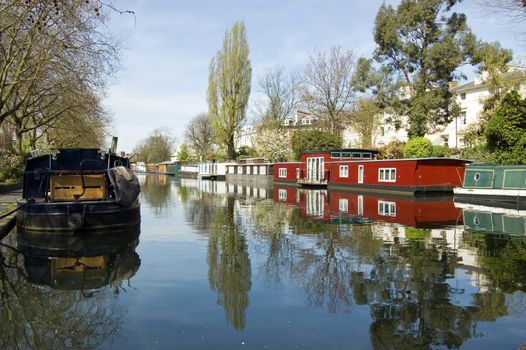 Rows of houseboats and narrow boats on the canal banks at Little Venice, Paddington, West London. The Grand Union Canal meets the Regent's Canal here.