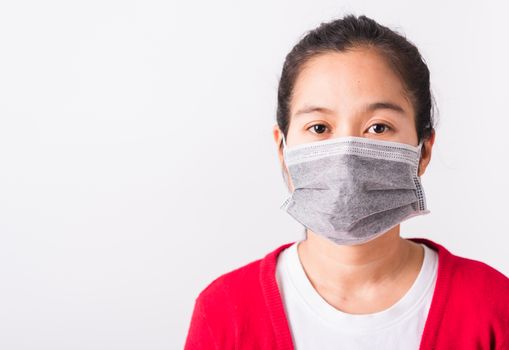 Asian adult woman wearing red shirt and face mask protective against coronavirus or COVID-19 virus or filter dust pm2.5 and air pollution she looking camera, studio shot isolated white background