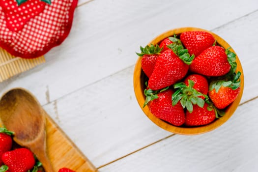 Organic strawberries on a bowl on a white wooden table much colorful