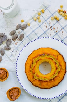 Organic corn cake with hazelnuts, coconut milk and chocolate candies in a square plate on a wooden table