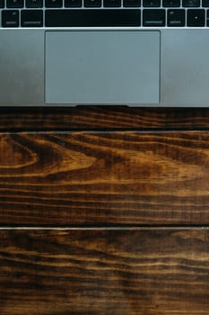 Gray laptop on a wooden table with large negative space