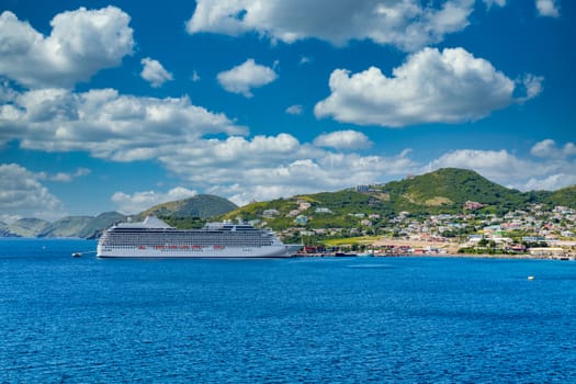 Luxury cruise ship anchored across a deep blue bay on St Kitts