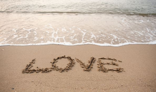 Write the word love on the sand