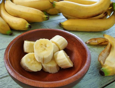 Banana slices placed in a wooden bowl.