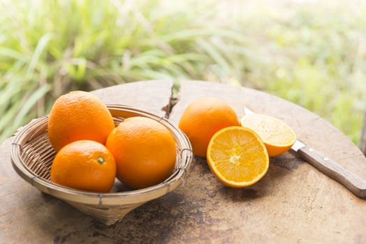 Woman cut orange on wooden table prepared to make orange juice.