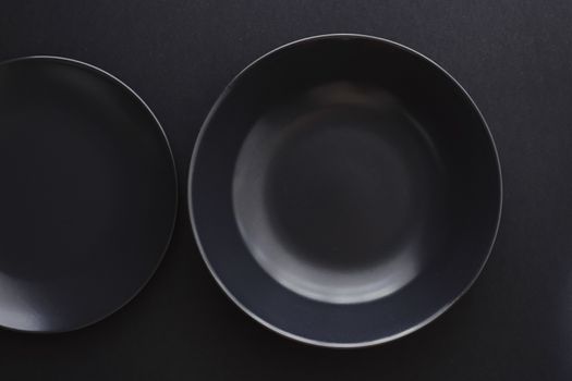 Empty plates on black background, premium dishware for holiday dinner, minimalistic design and diet concept