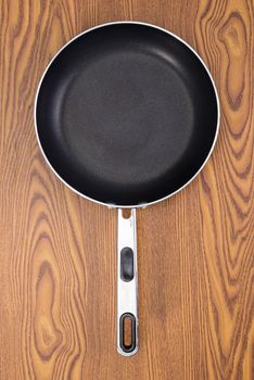non stick frying pans on wooden background