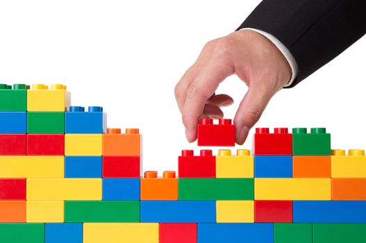 hand building up a wall by stacking up block