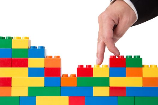 hand building up a wall by stacking up block