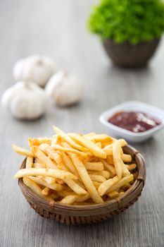 a bucket of french fried on wooden table