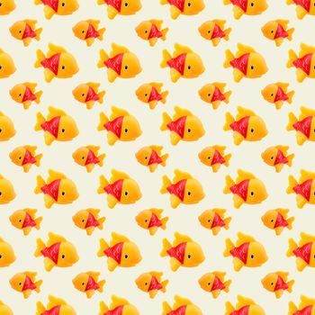 seamless pattern of rubber toy orange fish on white