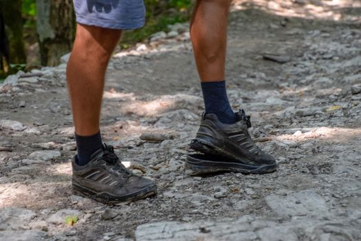 The detached sole on the tourist's sneakers. They broke their boots in the woods.