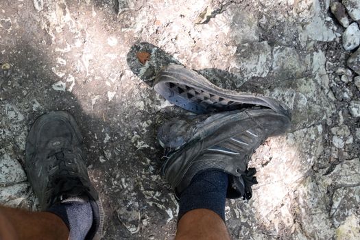 The detached sole on the tourist's sneakers. They broke their boots in the woods.