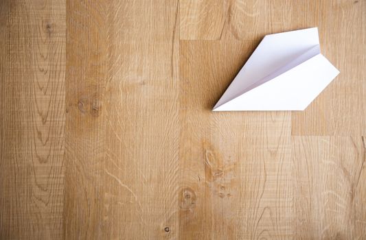 paper plane on wooden floor background