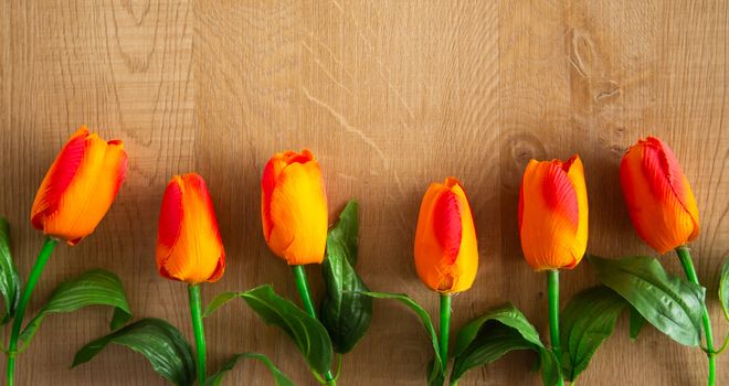 Tulips bunch on wooden background. Space for text.