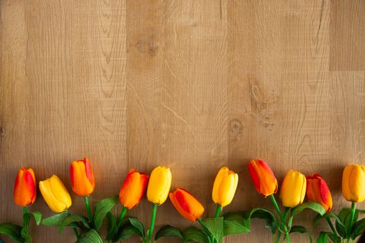 Tulips bunch on wooden background. Space for text.