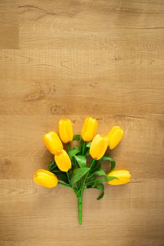 Tulips bunch on wooden background. Space for text.