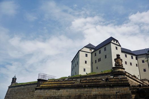 Koenigstein fortress and part of the surrounding wall in front of cloudy sky
