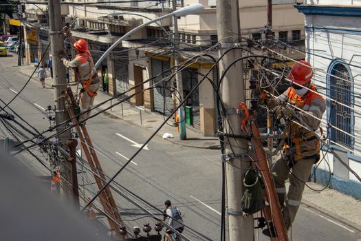 Men repairing electrical grid wires using masks because of COVID-19