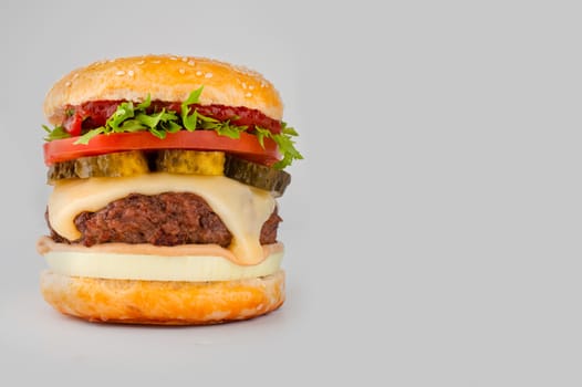 One big tall classic hamburger burger cheeseburger isolated on gray background with copy space